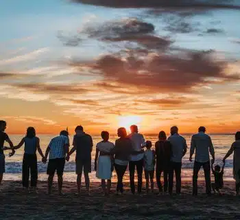 people standing on shore during golden hour