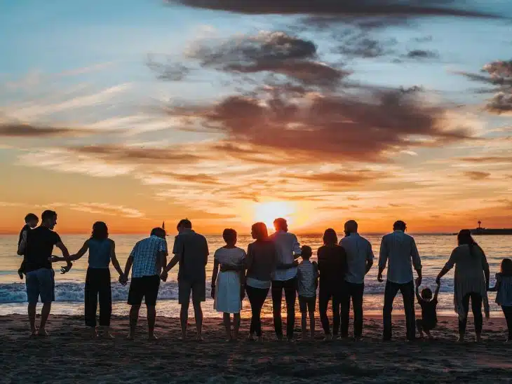 people standing on shore during golden hour